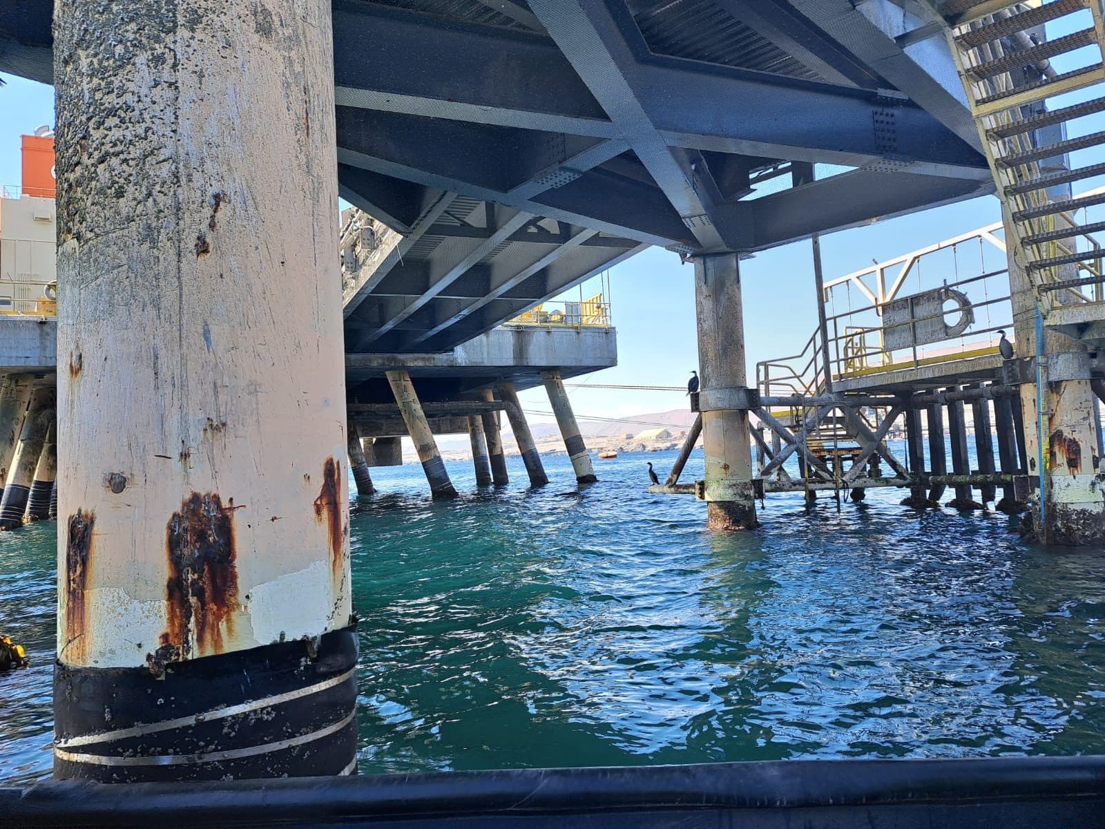 Jetty pile with anode protection over water