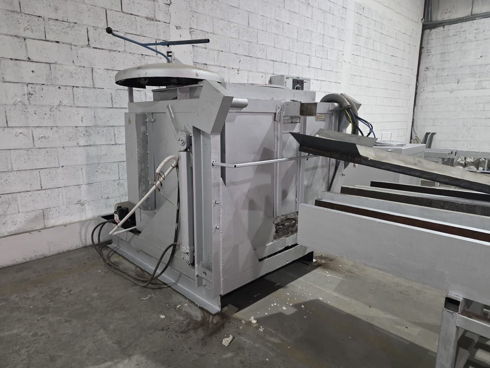 Tilting furnace at our foundry, with anode casting mold troughs in the foreground