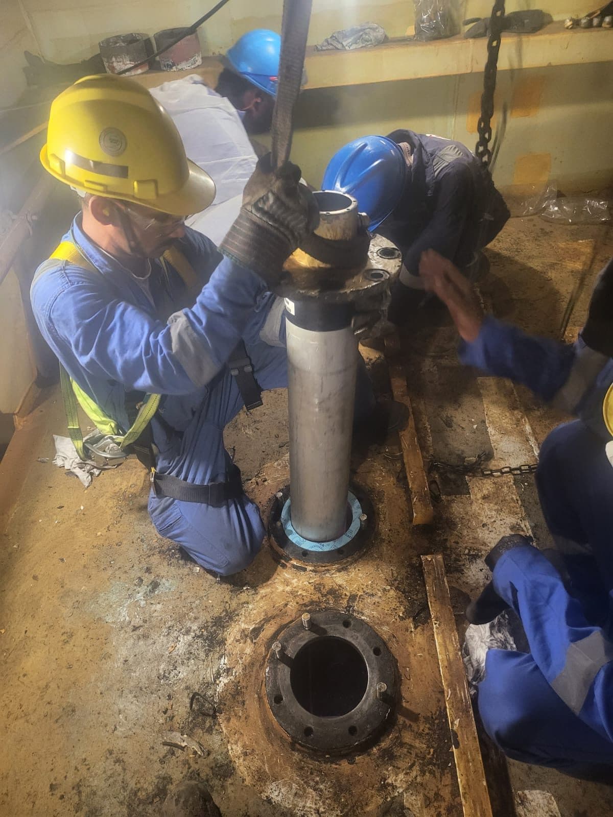 Team in full PPE installing an anode on a marine pile